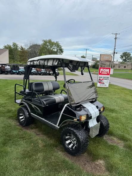 black Club Car DS 48V cart with striped canopy top and windshield