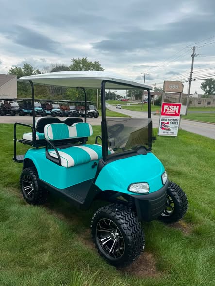 lifted-teal-ezgo-rxv-gas-cart-2 front view of the lifted teal EZGO RXV cart on all-terrain tires