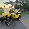 yellow-ezgo-express-s4-golf-cart-1 yellow EZGO Express S4 golf cart lifted with polished wheels at sunset