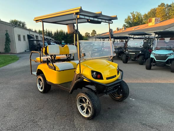 yellow-ezgo-express-s4-golf-cart-3 front view of the lifted yellow EZGO Express S4 golf cart
