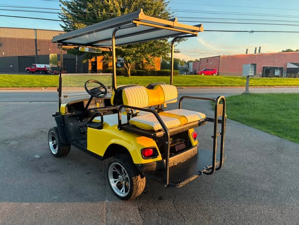 yellow-ezgo-express-s4-golf-cart-4 yellow EZGO Express S4 golf cart rear angle with white seats